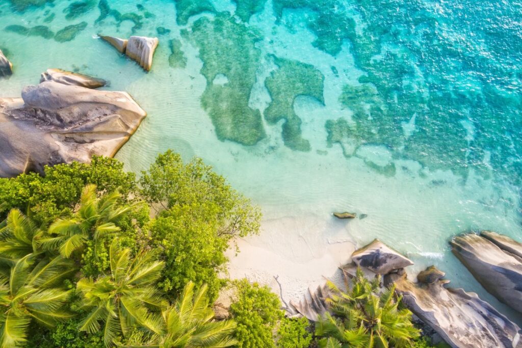 Seychelles Strengthens Global Ties with Key Emirates Partnership at Arabian Travel Market 2026 1 Aerial view of a Seychelles beach with granite boulders, palms and turquoise water